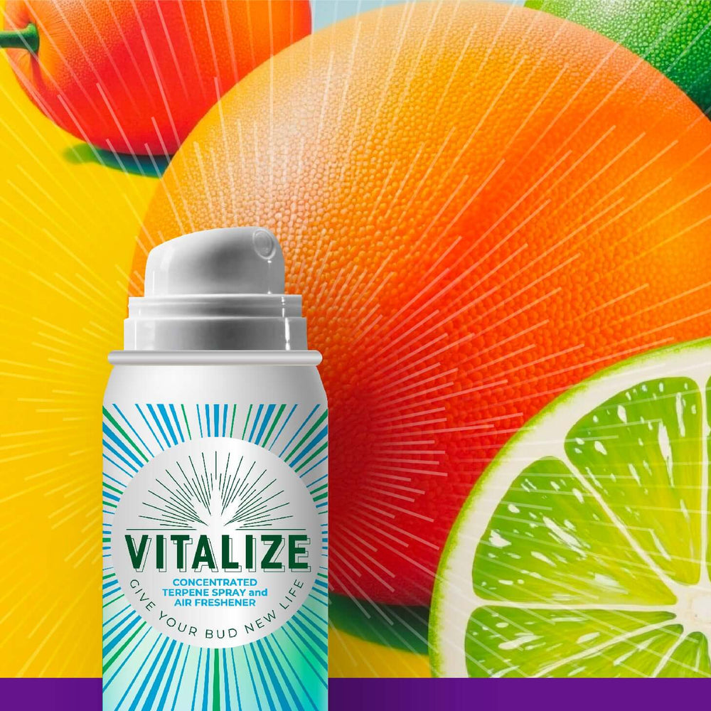 Sour Tangie Vitalize Terpene Spray in front of citrus fruits, enhancing flavor and aroma for dry herbs.
